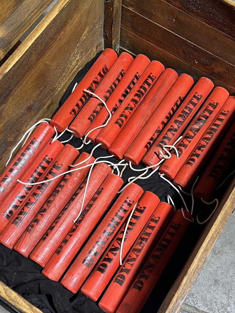 Détail des fausses charges de dynamite dans le coffre en bois